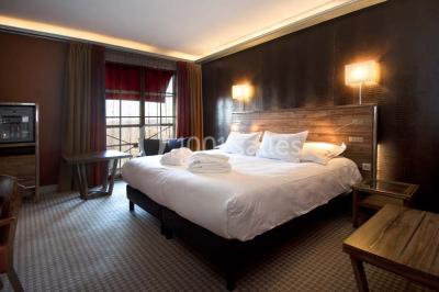 Salle de bain moderne avec lavabo blanc, douche vitrée, murs carrelés sombres et éclairage chaleureux.