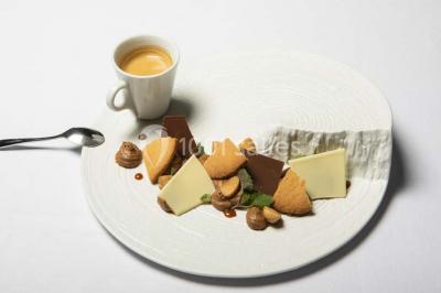 Salle de bain moderne avec lavabo blanc, douche vitrée, murs carrelés sombres et éclairage chaleureux.