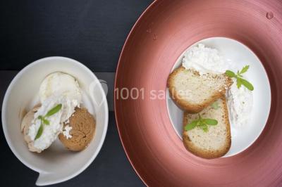 Salle de bain moderne avec lavabo blanc, douche vitrée, murs carrelés sombres et éclairage chaleureux.
