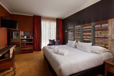 Salle de bain moderne avec lavabo blanc, douche vitrée, murs carrelés sombres et éclairage chaleureux.