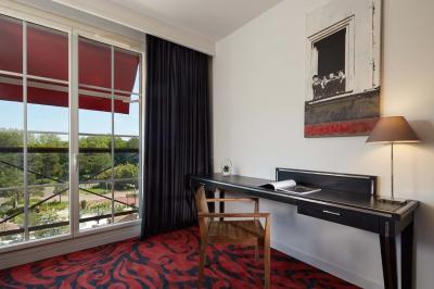 Salle de bain moderne avec lavabo blanc, douche vitrée, murs carrelés sombres et éclairage chaleureux.