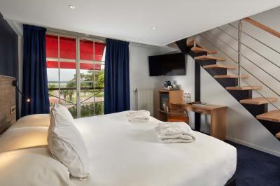 Salle de bain moderne avec lavabo blanc, douche vitrée, murs carrelés sombres et éclairage chaleureux.