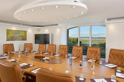 Salle de bain moderne avec lavabo blanc, douche vitrée, murs carrelés sombres et éclairage chaleureux.