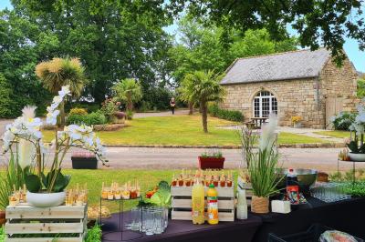 Chambre lumineuse avec un lit double couvert d'une housse à motifs noirs et blancs, près d'une fenêtre avec rideaux clairs.