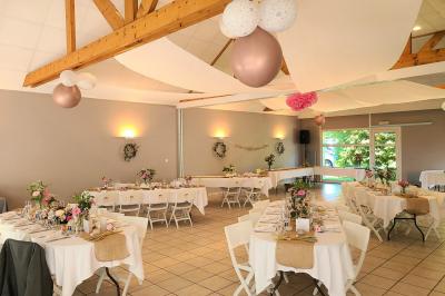 Chambre lumineuse avec un lit double couvert d'une housse à motifs noirs et blancs, près d'une fenêtre avec rideaux clairs.