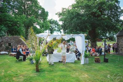 Chambre lumineuse avec un lit double couvert d'une housse à motifs noirs et blancs, près d'une fenêtre avec rideaux clairs.