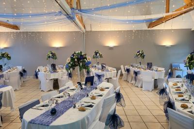 Chambre lumineuse avec un lit double couvert d'une housse à motifs noirs et blancs, près d'une fenêtre avec rideaux clairs.