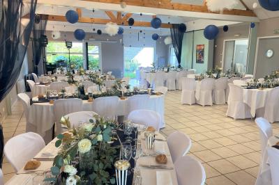 Chambre lumineuse avec un lit double couvert d'une housse à motifs noirs et blancs, près d'une fenêtre avec rideaux clairs.