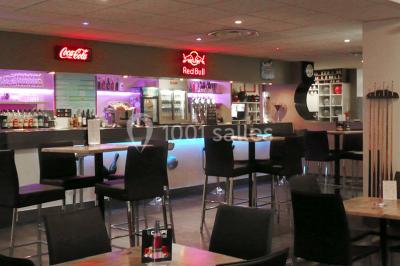 Logo circulaire jaune avec une boule de bowling noire frappant trois quilles blanches, accompagné du texte ’Bowling de…