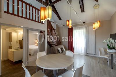 Vue d'un jardin avec pelouse, arbres, bancs rouges et une statue au centre, sous un ciel dégagé.