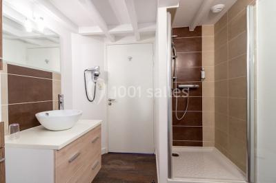 Vue d'un jardin avec pelouse, arbres, bancs rouges et une statue au centre, sous un ciel dégagé.