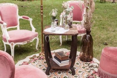 Vue d'un jardin avec pelouse, arbres, bancs rouges et une statue au centre, sous un ciel dégagé.