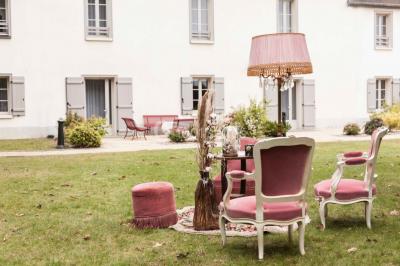 Vue d'un jardin avec pelouse, arbres, bancs rouges et une statue au centre, sous un ciel dégagé.