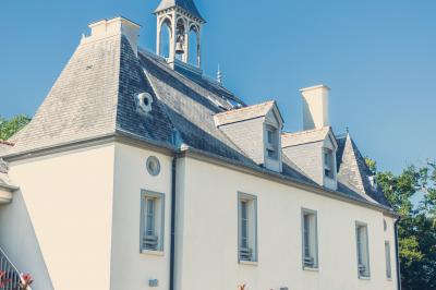 Vue d'un jardin avec pelouse, arbres, bancs rouges et une statue au centre, sous un ciel dégagé.