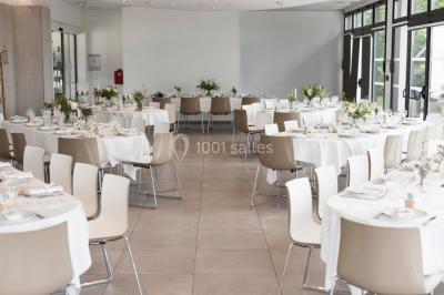 Miniature Salle de conférence Salle à manger lumineuse avec table ronde, chaises blanches, canapé beige, poutres apparentes et escalier en bois.