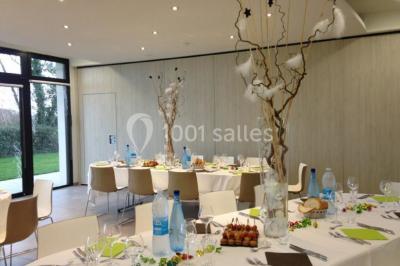 Miniature Salle de conférence Salle à manger lumineuse avec table ronde, chaises blanches, canapé beige, poutres apparentes et escalier en bois.