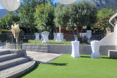 Table de réception élégamment dressée avec nappes blanches, serviettes décorées, verres et couverts alignés.