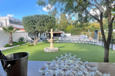Table de réception élégamment dressée avec nappes blanches, serviettes décorées, verres et couverts alignés.