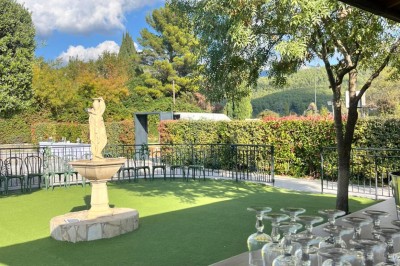 Table de réception élégamment dressée avec nappes blanches, serviettes décorées, verres et couverts alignés.