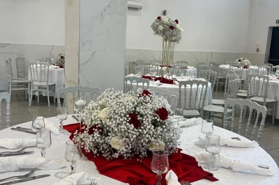 Table de réception élégamment dressée avec nappes blanches, serviettes décorées, verres et couverts alignés.