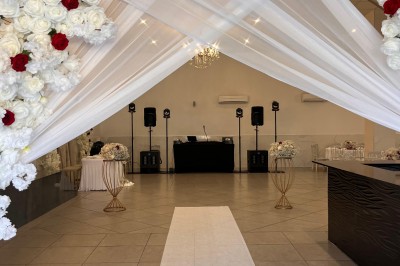 Table de réception élégamment dressée avec nappes blanches, serviettes décorées, verres et couverts alignés.