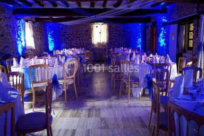 Grande pelouse bordée d'arbres avec une structure couverte et des chaises disposées en extérieur.