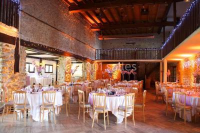 Grande pelouse bordée d'arbres avec une structure couverte et des chaises disposées en extérieur.