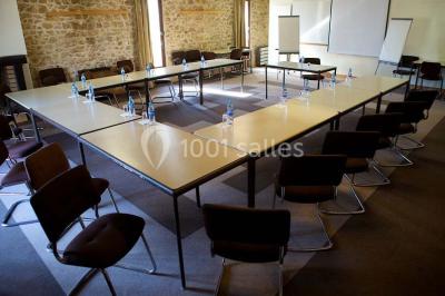 Grande pelouse bordée d'arbres avec une structure couverte et des chaises disposées en extérieur.