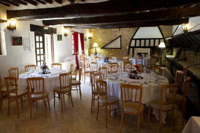 Grande pelouse bordée d'arbres avec une structure couverte et des chaises disposées en extérieur.