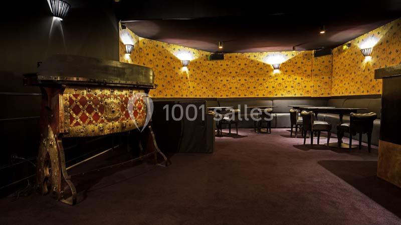 Salle avec murs jaunes ornés de motifs, mobilier sombre et un grand meuble décoratif en premier plan.