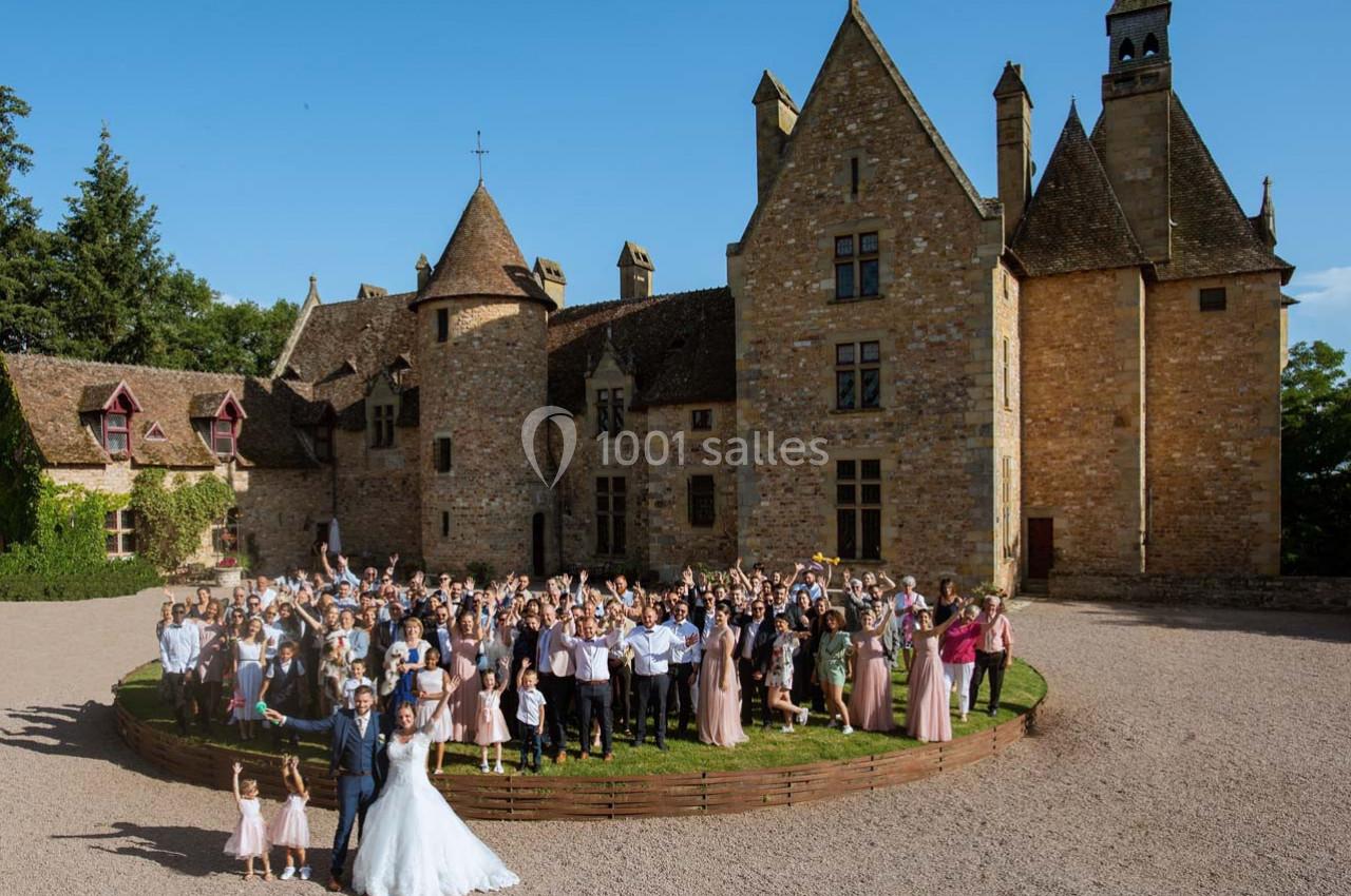 Location salle Vallon-en-Sully (Allier) - Château de Peufeilhoux #1 Un grand groupe de personnes posant devant un château en pierre sous un ciel bleu.