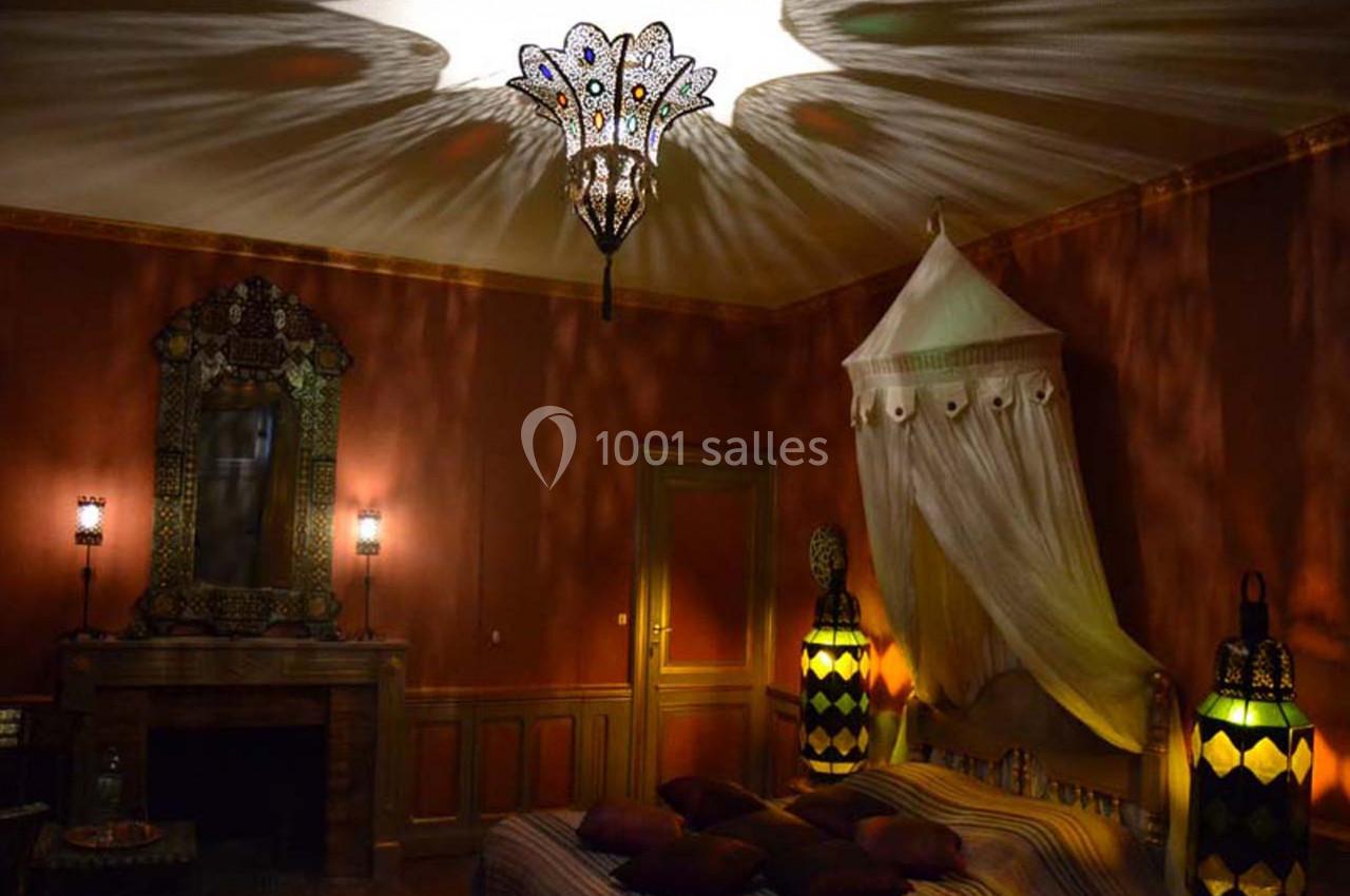 Chambre Shéhérazade Chambre décorée dans un style oriental avec un lit à baldaquin, des lampes colorées et un éclairage tamisé.