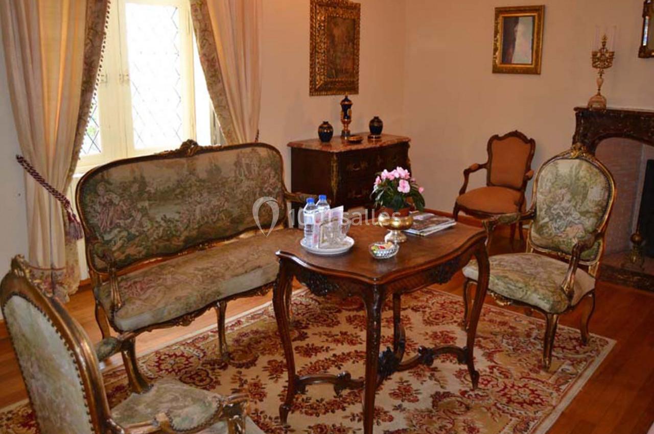 Salon chambre Pompadour Salon ancien avec mobilier d'époque, comprenant un canapé, des fauteuils, une table en bois et un tapis orné.