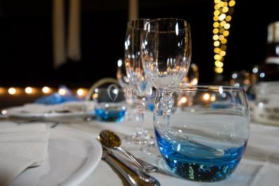 Lit double avec draps blancs, coussins décoratifs noirs et blancs, lampe de chevet allumée et tableau mural coloré.