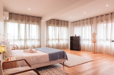 Vue d'un jardin avec allée gravillonnée, haies taillées, pelouse et arbres en arrière-plan sous un ciel dégagé.