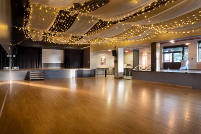 Vue d'un jardin avec allée gravillonnée, haies taillées, pelouse et arbres en arrière-plan sous un ciel dégagé.