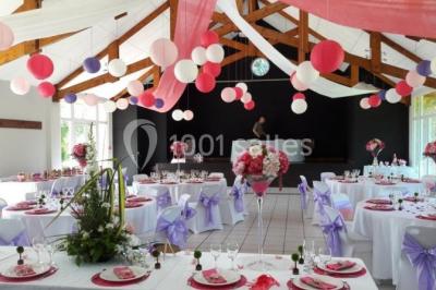 Cuisine professionnelle avec plan de travail en inox, cuisinière équipée et hotte, éclairée par une fenêtre.