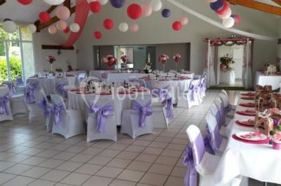 Cuisine professionnelle avec plan de travail en inox, cuisinière équipée et hotte, éclairée par une fenêtre.