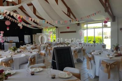 Cuisine professionnelle avec plan de travail en inox, cuisinière équipée et hotte, éclairée par une fenêtre.