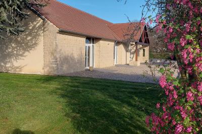 Cuisine professionnelle avec plan de travail en inox, cuisinière équipée et hotte, éclairée par une fenêtre.