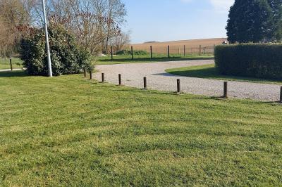 Cuisine professionnelle avec plan de travail en inox, cuisinière équipée et hotte, éclairée par une fenêtre.