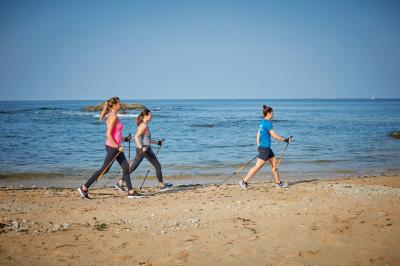 Salle de restaurant lumineuse avec tables dressées, chaises violettes, luminaires dorés et grandes baies vitrées.