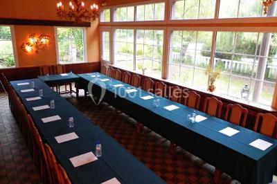 Table décorée en extérieur avec des amuse-bouches, un vase de fleurs hautes et des éléments végétaux sous un arbre.
