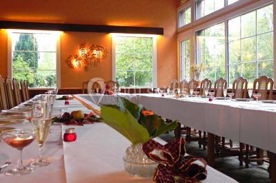 Table décorée en extérieur avec des amuse-bouches, un vase de fleurs hautes et des éléments végétaux sous un arbre.