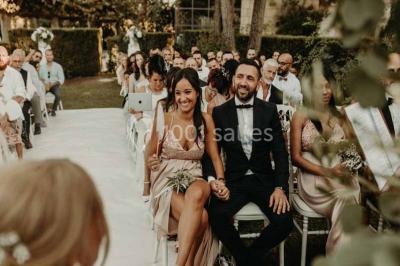 Salle de bain avec baignoire encastrée, lavabo sur meuble en marbre beige et fenêtre laissant entrer la lumière naturelle.