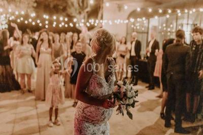 Salle de bain avec baignoire encastrée, lavabo sur meuble en marbre beige et fenêtre laissant entrer la lumière naturelle.
