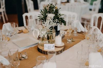 Salle de bain avec baignoire encastrée, lavabo sur meuble en marbre beige et fenêtre laissant entrer la lumière naturelle.