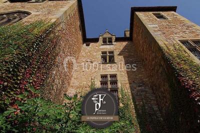 Une équipe de tournage filme une table dressée avec des plats et des chandeliers dans une pièce décorée.