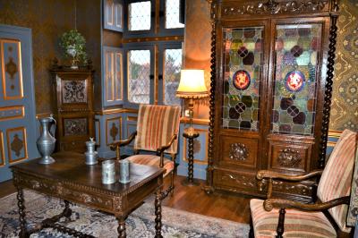 Une équipe de tournage filme une table dressée avec des plats et des chandeliers dans une pièce décorée.