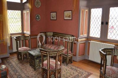 Une équipe de tournage filme une table dressée avec des plats et des chandeliers dans une pièce décorée.